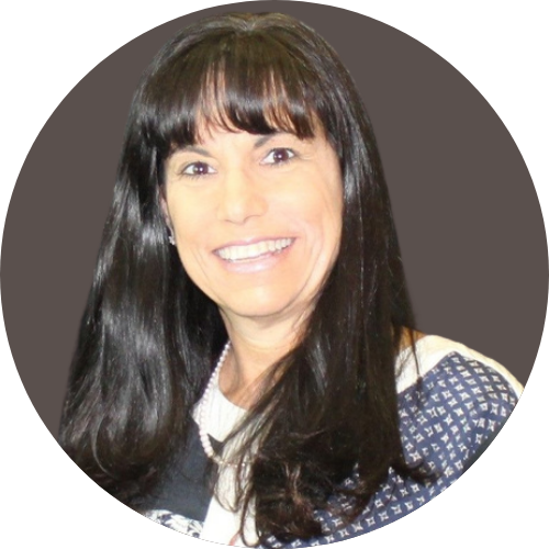 Marla Grassgreen, Caucasian women with long dark hair smiling in a patterned top with a neutral background